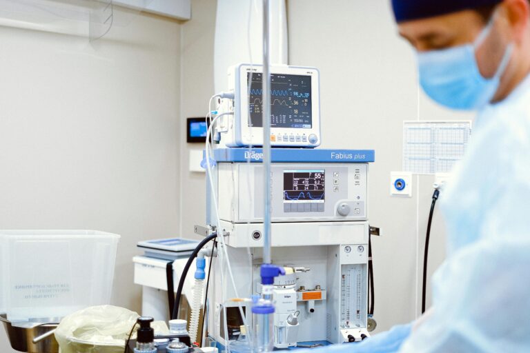 Mesical professional wearing a mask standing in front of medical apparatuses